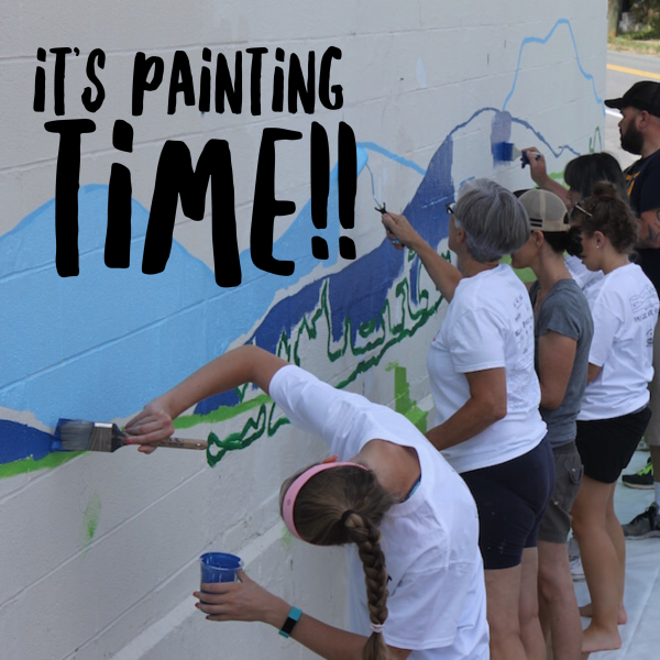 Volunteers painting a public art mural